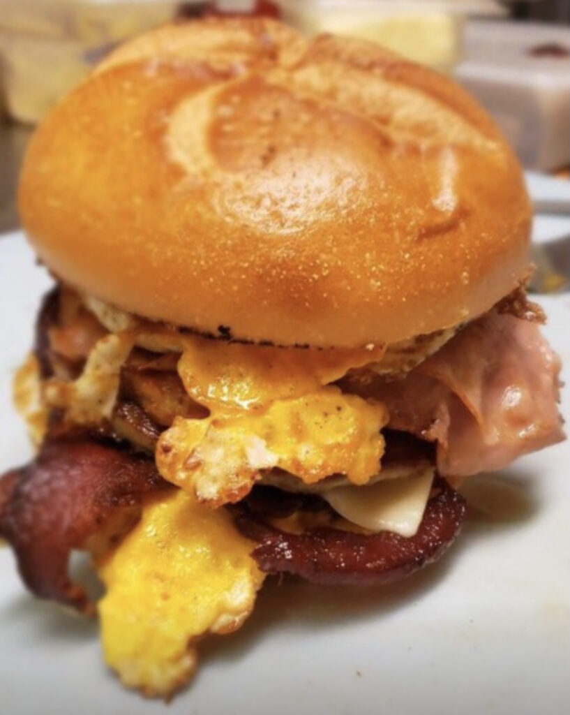 Simply Food by Maura's The Horseman sandwich with ham, sausage, bacon, a hash brown, cheese and eggs on a hard roll. 